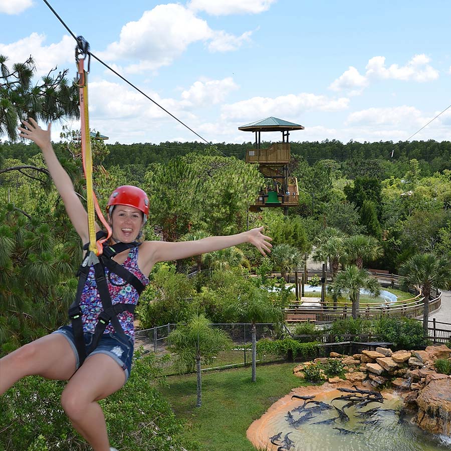 Woman rides the Screamin' Gator Zipline at Gatorland